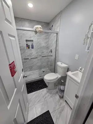 a bathroom with a shower and a toilet at Newly Renovated Detached Studio apartment in Irvington
