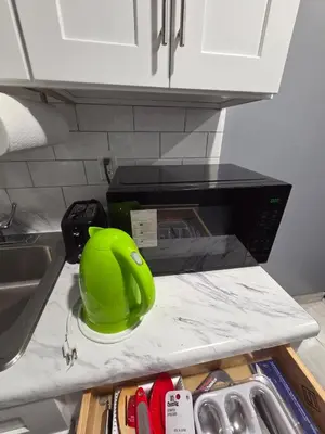 a green helmet sitting on a counter next to a microwave at Newly Renovated Detached Studio apartment in Irvington
