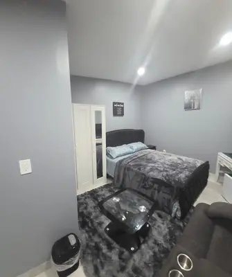 a bedroom with a bed and a couch in it at Newly Renovated Detached Studio apartment in Irvington