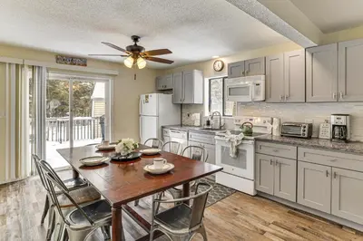 a kitchen with a table with chairs and a ceiling fan at Steps to Lake! Family Haven with Hot Tub in Poconos in Tobyhanna