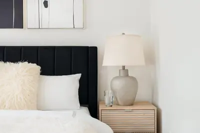 a bed with a black headboard and a lamp on a night stand at 48-4FE 2BR Prime Midtown West in New York