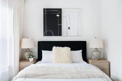a bedroom with a black and white bed with two lamps at 48-4FE 2BR Prime Midtown West in New York