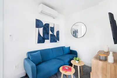 a blue couch in a living room with a mirror at 48-4FE 2BR Prime Midtown West in New York