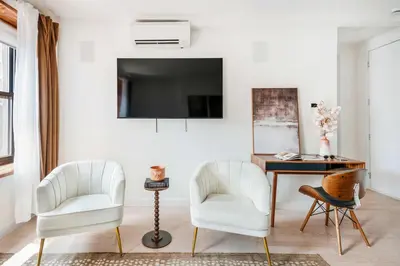 a living room with two white chairs and a desk at 319-3A XL New Modern 1BR Union Square WD in Unit in New York