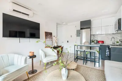a living room with a couch and a kitchen at 319-3A XL New Modern 1BR Union Square WD in Unit in New York