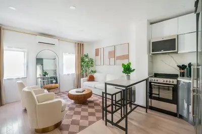 a kitchen and living room with a table and a couch at 317-4B Brand New Modern 1BR Union Square WD in Unit in New York