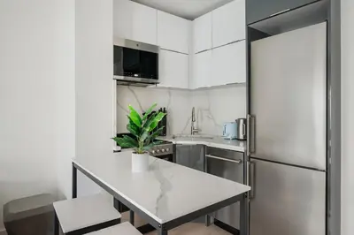 a kitchen with a table and a refrigerator at 317-4B Brand New Modern 1BR Union Square WD in Unit in New York