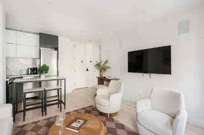 a living room with two white chairs and a table at 317-4B Brand New Modern 1BR Union Square WD in Unit in New York