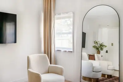 a living room with white chairs and a mirror at 317-4B Brand New Modern 1BR Union Square WD in Unit in New York