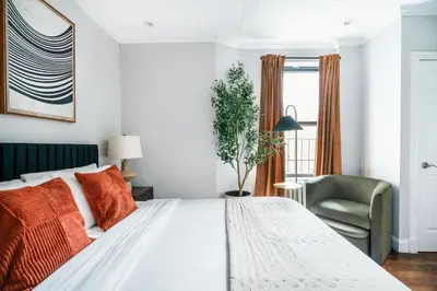 a bedroom with a white bed and a green chair at Mott-9 Prime Soho Cozy New Studio WD in the unit in New York