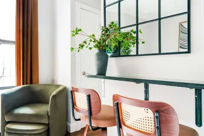 a room with two chairs and a table and a mirror at Mott-9 Prime Soho Cozy New Studio WD in the unit in New York