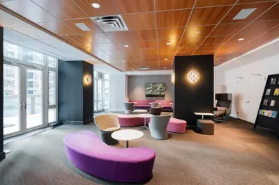 a room with purple chairs and tables in a building at 43-20A Newly furnished 1BR- full service Doorman laundry Gym Business Center in New York