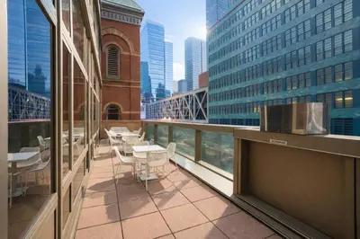 a balcony with tables and chairs on a building at 43-20A Newly furnished 1BR- full service Doorman laundry Gym Business Center in New York