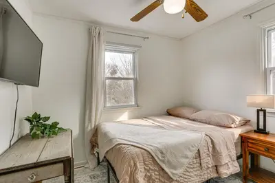 a bedroom with a bed and a flat screen tv at Walk to Lake Hopatcong Vibrant Home with Deck! in Hopatcong