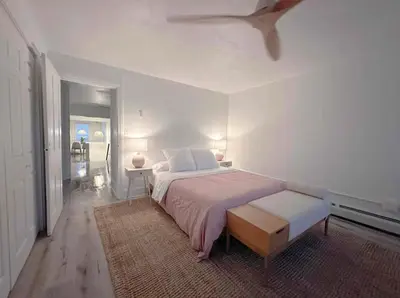 a white bedroom with a large bed and a table at Chic Phoenixville Retreat With Parking in Phoenixville