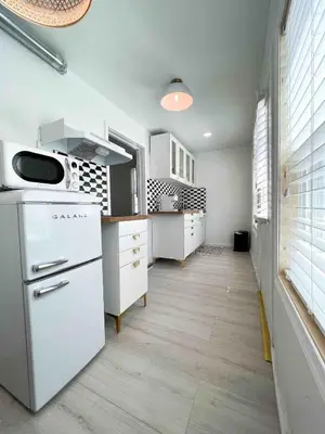 a kitchen with white counters and a white refrigerator at Chic Phoenixville Retreat With Parking in Phoenixville