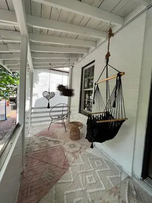 a porch with a swing and a chair on a house at Queen Bed, Luxury Studio with Balcony in Phoenixville