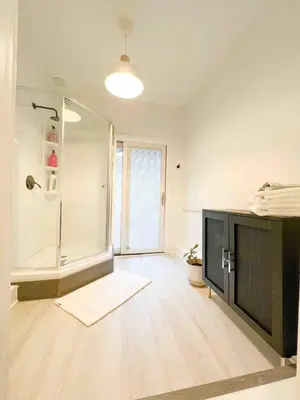 a large bathroom with a shower and a television at Queen Bed, Luxury Studio with Balcony in Phoenixville