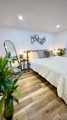 a bedroom with a large bed and a wooden floor at Cozy 1BR in Philly and Rain Shower in Philadelphia