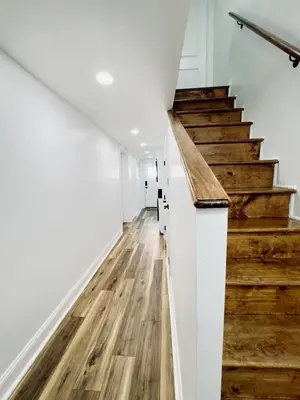 a hallway with wooden floors and stairs in a house at Cozy 1BR in Philly and Rain Shower in Philadelphia