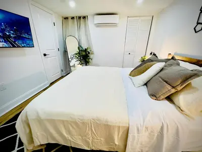 a bedroom with a large white bed with pillows at Cozy 1BR in Philly and Rain Shower in Philadelphia