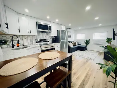 a kitchen with white cabinets and a wooden table at Cozy 1BR in Philly and Rain Shower in Philadelphia
