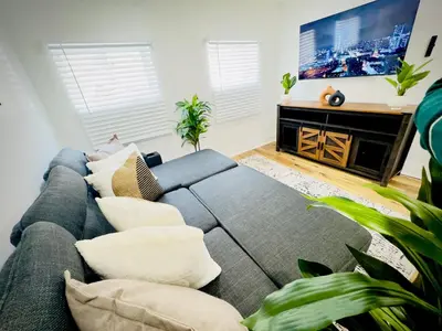 a living room with a couch and a flat screen tv at Cozy 1BR in Philly and Rain Shower in Philadelphia