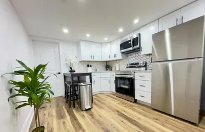 a kitchen with white cabinets and a stainless steel refrigerator at Cozy 1BR in Philly and Rain Shower in Philadelphia