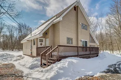 a house with a porch in the snow at Cabin in Lakeside Community! Poconos Getaway in Albrightsville