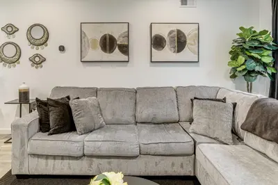 a living room with a gray couch with pillows at 2 Mi to The Met Philadelphia Home with Rooftop Deck in Philadelphia