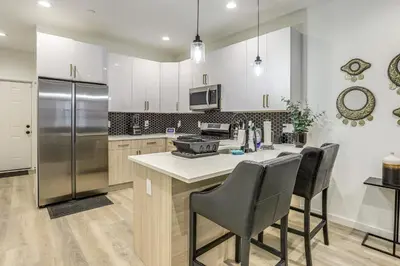 a kitchen with white cabinets and a stainless steel refrigerator at 2 Mi to The Met Philadelphia Home with Rooftop Deck in Philadelphia