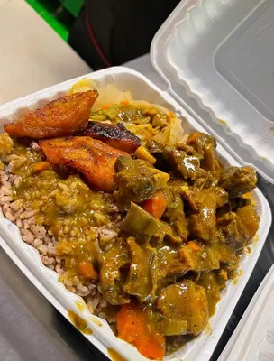 a plate of food with chicken and vegetables on rice at Caribbean Deck Estate in Effort