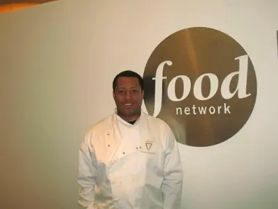 a man standing in front of a food network sign at Caribbean Deck Estate in Effort