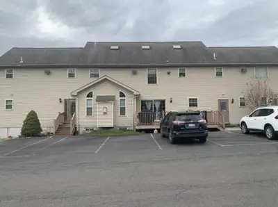 a large building with cars parked in a parking lot at Caribbean Deck Estate in Effort