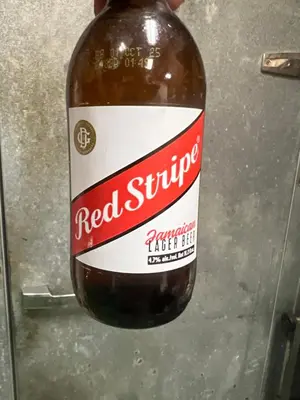 a bottle of red sauce sitting on a counter at Caribbean Deck Estate in Effort