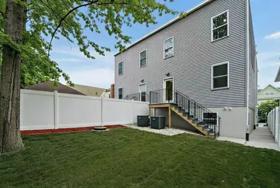 a house with a white fence next to a yard at 4BR5BA Luxury World Cup hub in North Bergen