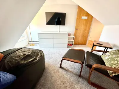 a attic bedroom with a bed and a tv at Cozy 3BR Home - Hudson Valley views near Woodbury Commons in Highland Mills