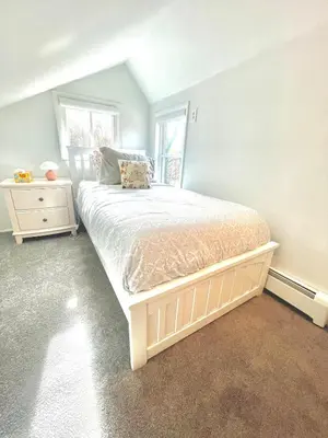 a bedroom with a large bed and two windows at Cozy 3BR Home - Hudson Valley views near Woodbury Commons in Highland Mills