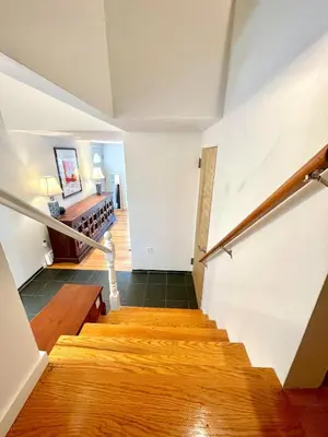 a staircase in a home with wooden floors and white walls at Cozy 3BR Home - Hudson Valley views near Woodbury Commons in Highland Mills