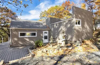 a home with a gray house at Cozy 3BR Home - Hudson Valley views near Woodbury Commons in Highland Mills