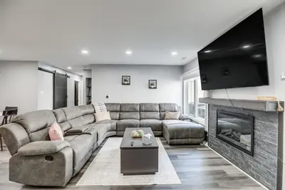 a living room with a couch and a fireplace at Easy Commute to Philly Traveling Pros Hub! in Levittown