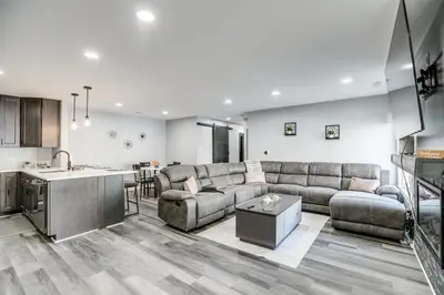 a living room with a couch and a kitchen at Easy Commute to Philly Traveling Pros Hub! in Levittown