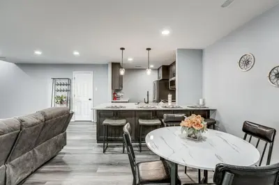 a kitchen and living room with a table and chairs at Easy Commute to Philly Traveling Pros Hub! in Levittown