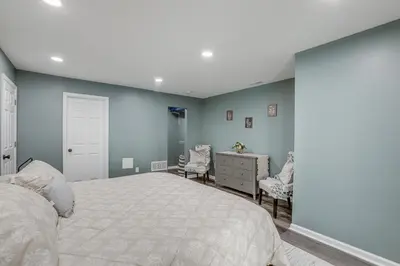 a bedroom with a bed and a dresser and chairs at Easy Commute to Philly Traveling Pros Hub! in Levittown