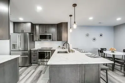 a kitchen with stainless steel appliances and a table at Easy Commute to Philly Traveling Pros Hub! in Levittown