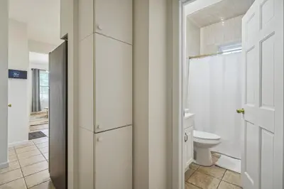 a white bathroom with a toilet and a window at NYC Escape Easy Transit Easy Parking Quiet Area in Teaneck