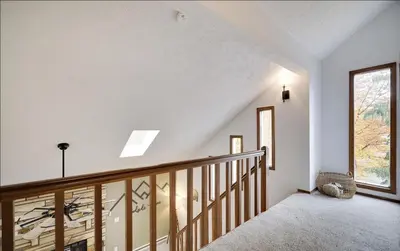 a staircase in a home with white walls and a window at Woodside Haven - Game Room - Central AC - Pet Friendly in Tobyhanna