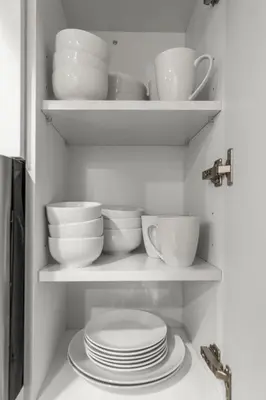 a cabinet filled with plates and bowls and cups at Modern 1 BR Apartment Near Center City & University City in Philadelphia