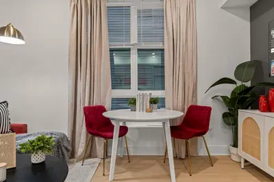 a dining room with a white table and red chairs at Modern 1 BR Apartment Near Center City & University City in Philadelphia