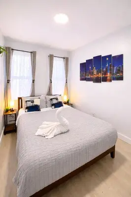 a bedroom with a bed with a swan on it at Cozy 3BR Apt in Jersey City! near NYC & Metlife! in Jersey City